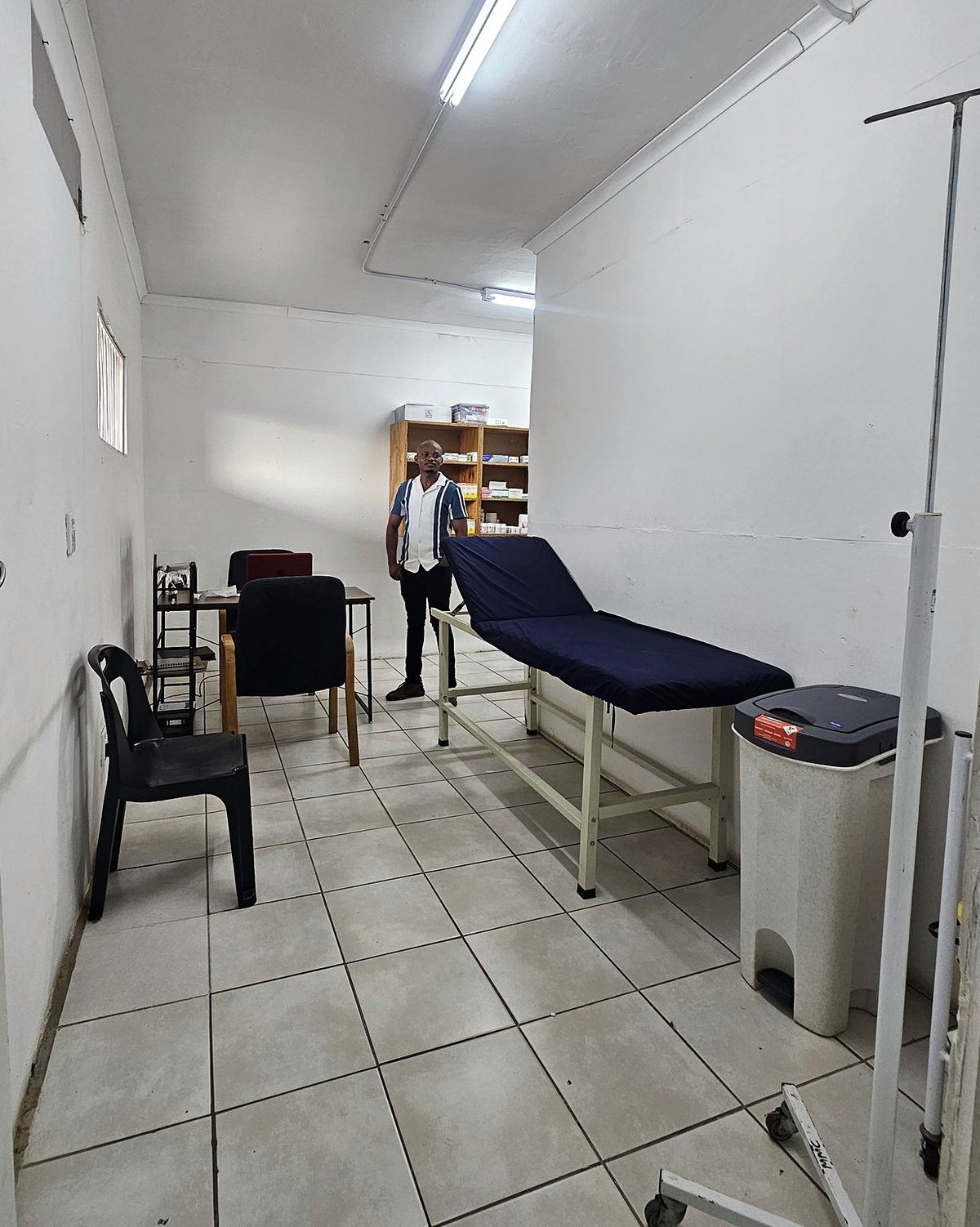 The consulting room with an examination bed and desk